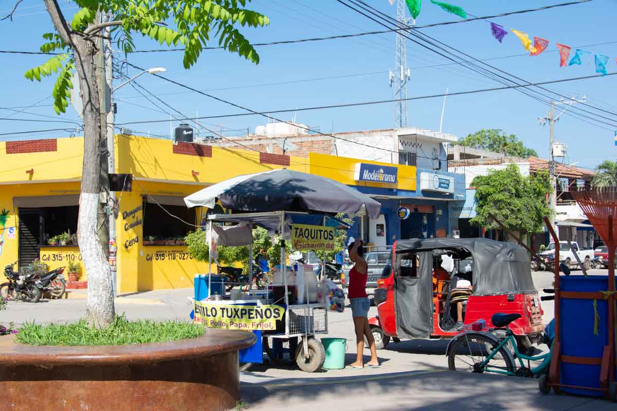 A taco cart beside a Mexican square.